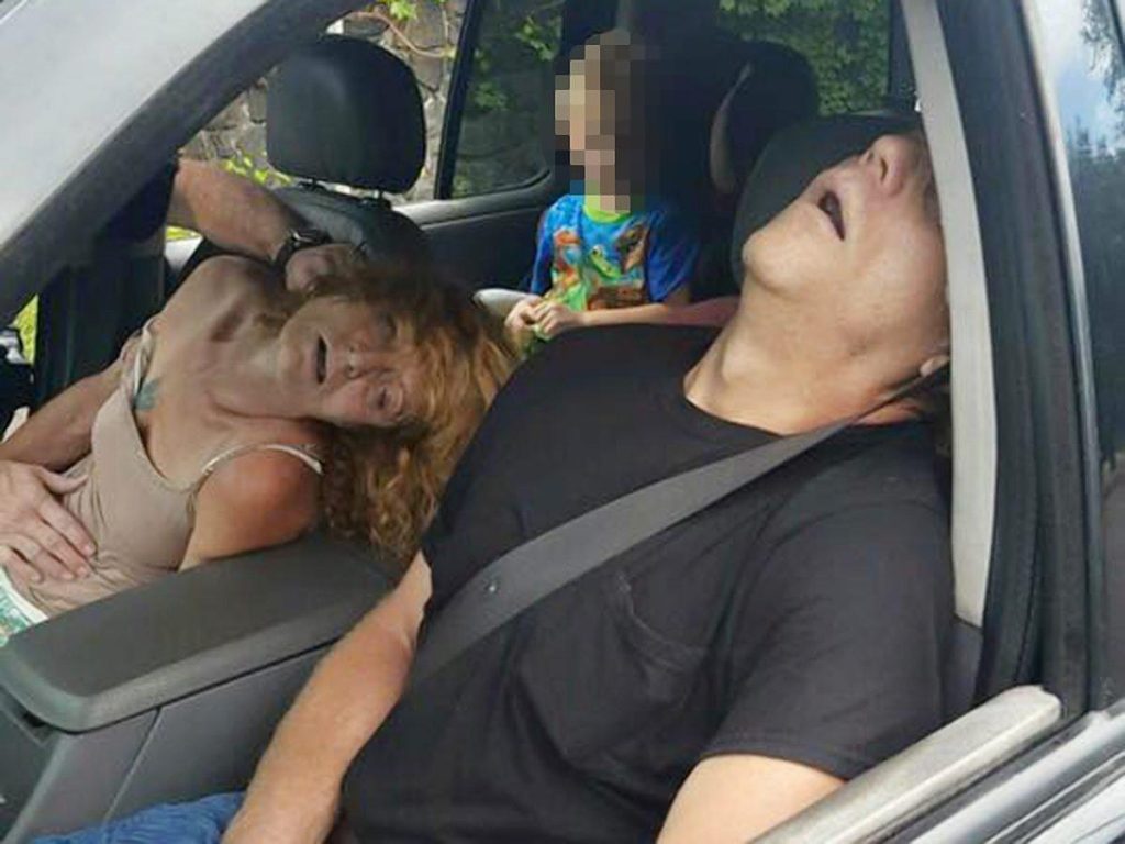 Politiet deler dette bildet til skrekk og advarsel: Fireåring sitter alene i baksetet på en bil, mens foreldrene sover ut