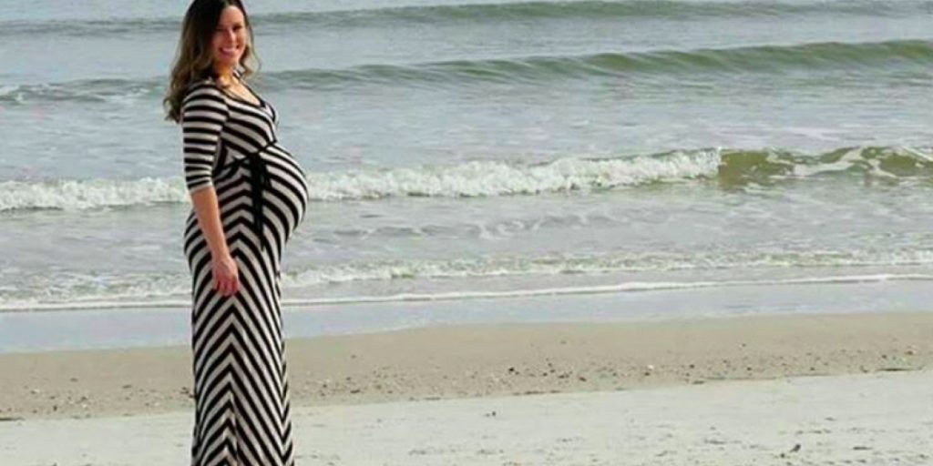 Pappa tar bilde av tungt gravid kone på stranden, men plutselig vises noe uventet i bakgrunnen